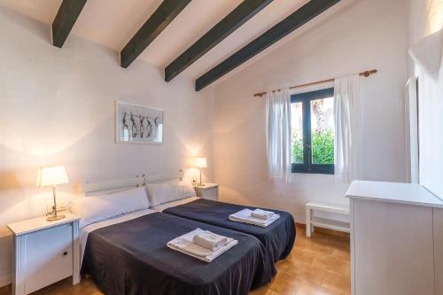 a bedroom with a large bed with two towels on it at Casa 4 P en Complejo Binisafua in Binisafua