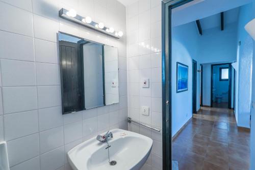 a white bathroom with a sink and a mirror at Casa 4 P en Complejo Binisafua in Binisafua