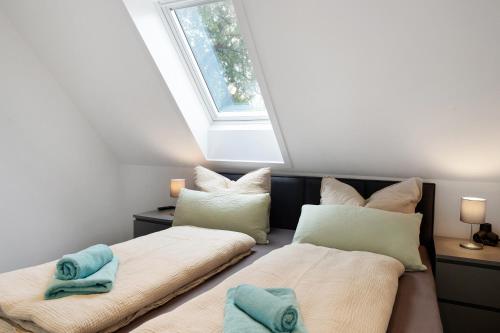 two beds in a room with a window at Haus Kirchenblick in Kalkhorst