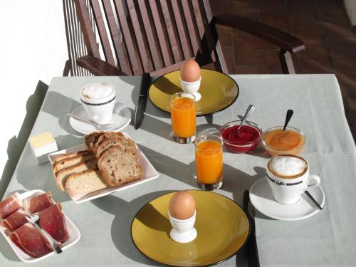 un tavolo con uova, pane e tazze di caffè di Quinta Quinze a Boliqueime