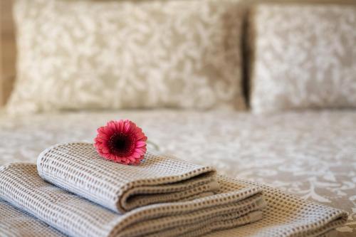 a pink flower sitting on top of a pillow on a bed at Casa Rosada Monza Autodromo in Nova Milanese