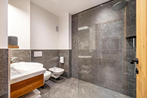 a bathroom with a toilet and a sink and a shower at Ferienwohnung Gruberhof in Verano