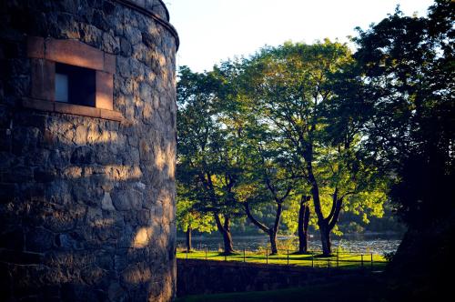 a stone building with trees in the background at Oscarsborg Castle Hotel & Resort in Drøbak