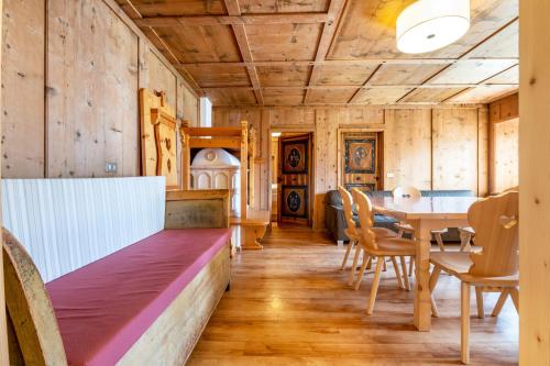 a room with a bench and a table and chairs at Muncion Apparte in Pozza di Fassa