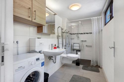 a bathroom with a sink and a washing machine at Apartment Alte Poststation in Wehr
