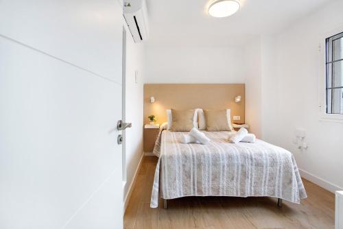 a white bedroom with a bed and a window at Liomor Luxury in Caleta De Fuste
