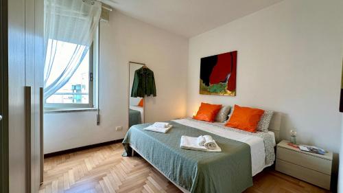 a bedroom with a bed with orange pillows and a window at A casa di Deborah in Padova