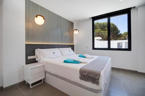 a bedroom with a large white bed with a window at Lola Sea Villa in Novo Sancti Petri