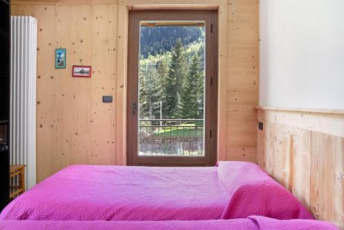 a bedroom with a bed and a window with a view at Alta Valle Maira C in Acceglio