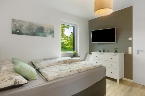 a bedroom with a bed and a tv on the wall at Ferienwohnung Viedenz in Drolshagen