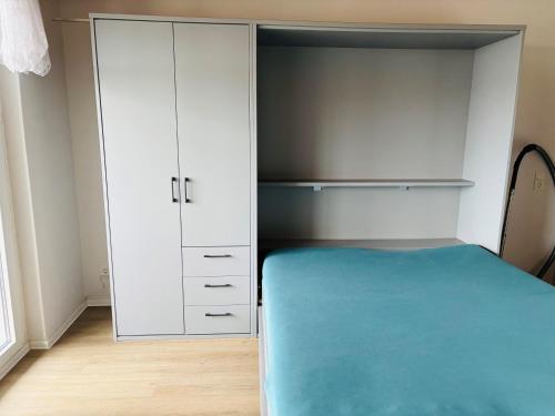 a bedroom with a bed and a white closet at Apartment Dargies in Cuxhaven