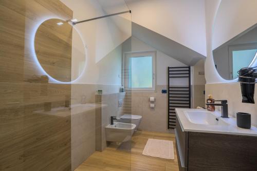 a bathroom with a toilet and a sink and a mirror at Casa Titi in Malcesine