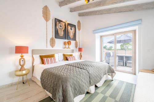 a white bedroom with a bed and a window at Ca na Rossa in Sineu