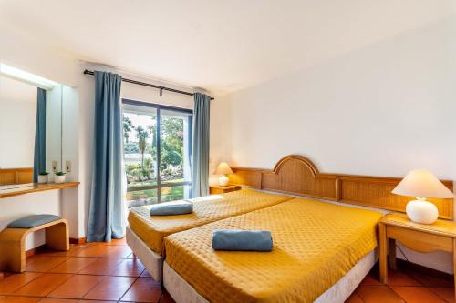 a bedroom with a yellow bed and a window at Casa N's in Albufeira