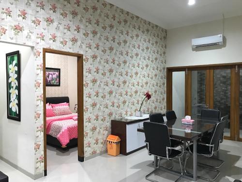 a bedroom with a bed and a table and chairs at Nariska Suite Homestay Purwokerto in Purwokerto