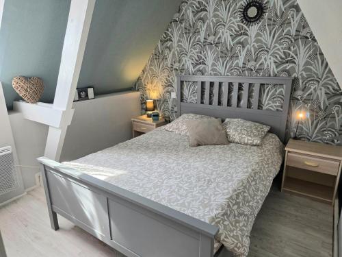 a bedroom with a bed with a large headboard at Jolie Maison Cyprange in Pirou