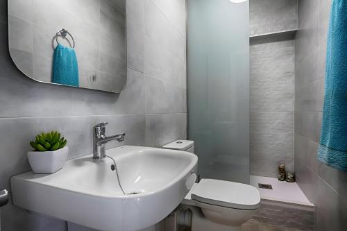 a white bathroom with a sink and a toilet at Brasil Mar in Playa de Gandia