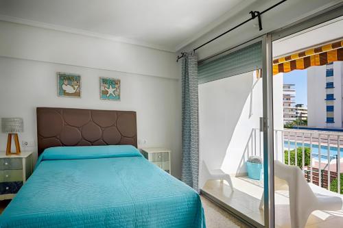 a bedroom with a bed and a balcony at Brasil Mar in Playa de Gandia