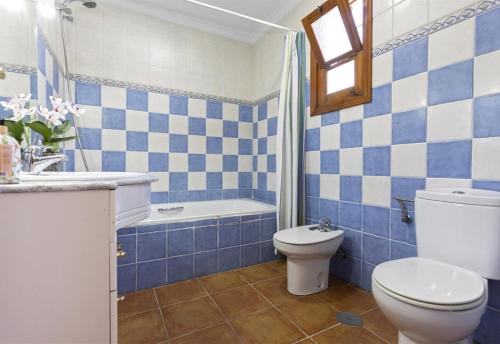 a blue and white bathroom with a toilet and a tub at El Puntal de Nieves in Nerja