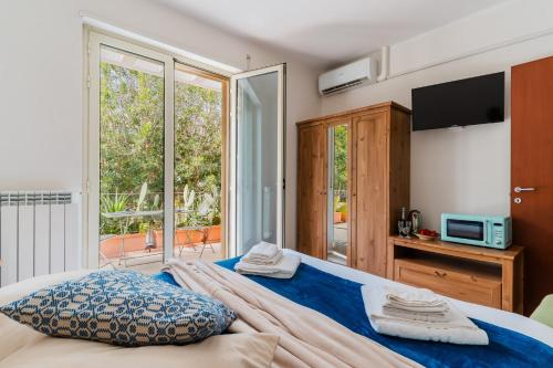 a bedroom with a bed with a tv and a balcony at Andromeda's Rooms in Otranto