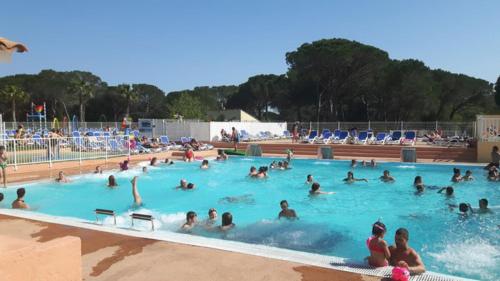 a group of people swimming in a swimming pool at Mobilhome Topaze in Puget-sur-Argens