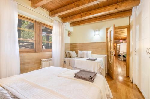 two beds in a room with wooden ceilings at Moli in Oden