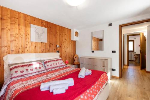 a bedroom with a red bed with towels on it at Maison du coeur - Bien-être in Challand Saint Anselme