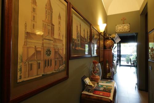 a hallway with paintings on the wall and a table at Il Giardinetto in Vercelli