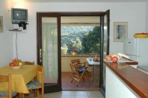 a kitchen and dining room with a table and a television at Appartamenti Le Querce App. Ginestra in Capoliveri