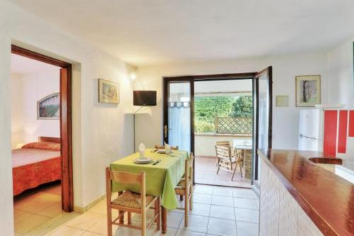 a room with a table and a room with a bedroom at Appartamenti Le Querce App. Ginestra in Capoliveri