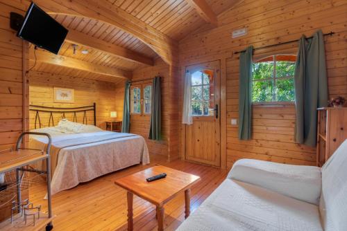 a log cabin with two beds and a couch at Entre Viejos Olivos in Benicolet
