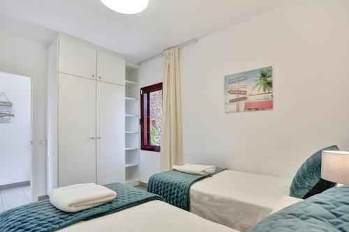a white room with two beds and a window at Casa Mavadel in La Oliva