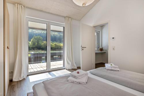 ein Schlafzimmer mit zwei Betten und einem großen Fenster in der Unterkunft Nadou in Beuron
