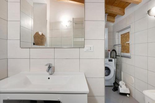 a white bathroom with a sink and a washing machine at Donadelmar2 in Riomaggiore