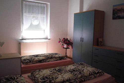 a bedroom with two beds and a dresser and a window at Ferienwohnung Rose in Schöneck