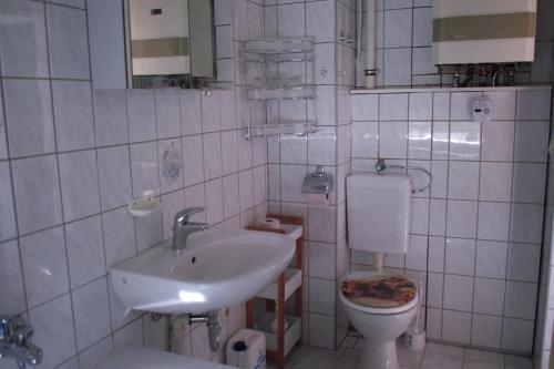 a white bathroom with a sink and a toilet at Ferienwohnung Rose in Schöneck