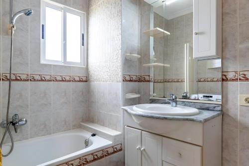 a bathroom with a sink and a tub and a shower at Costamar Oceanview 1 Bed Apartment in Arona