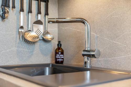 a kitchen sink with a faucet and utensils at Fewo Brünnstein - Nr 13 Pool, Sauna in Oberaudorf