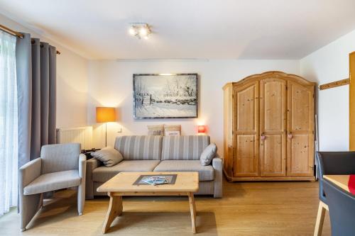 a living room with a couch and a table at Fewo Brünnstein - Nr 13 Pool, Sauna in Oberaudorf