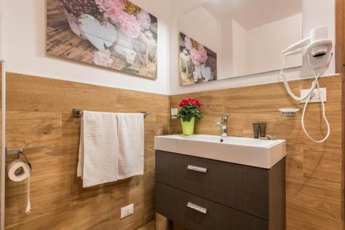 a bathroom with a sink and flowers on the wall at Casa Ferrazza Michelle in Madonna di Campiglio