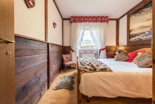a bedroom with a bed and a window at Casa Ferrazza Michelle in Madonna di Campiglio