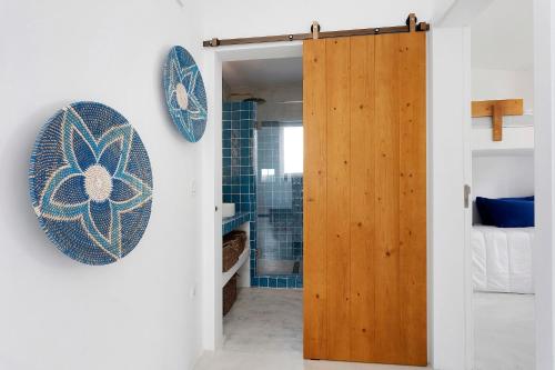 a bathroom with a wooden door and a shower at Casa da Praia Valmitão in Ribamar