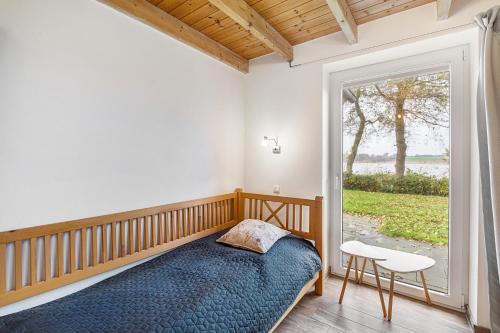 a bedroom with a bed and a large window at Rosenuferhaus in Kosel