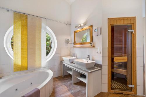 a bathroom with two sinks and a tub and a mirror at Rosenuferhaus in Kosel