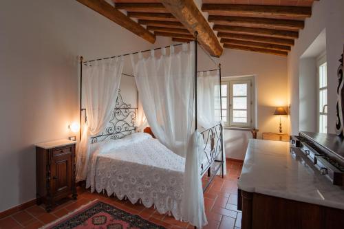 a bedroom with a bed with a canopy at Villa con piscina in Capannori