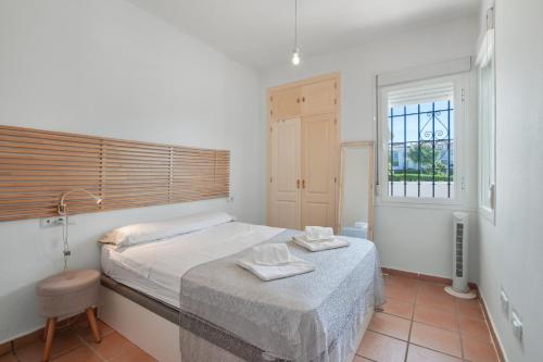 a bedroom with a bed with two towels on it at Con piscina en playa Islantilla in Islantilla