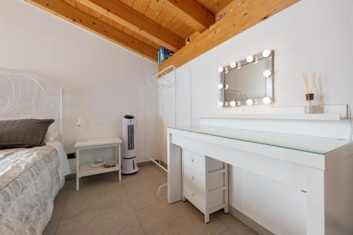 a bedroom with a bed and a vanity with a mirror at Il Nido Del Colibrì in Stazzona