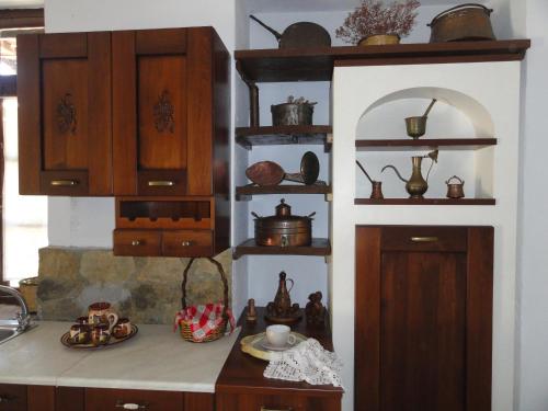 a kitchen with wooden cabinets and a counter with dishes at Zeus House in Agios Konstantinos