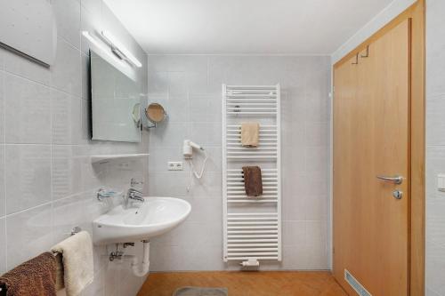 a white bathroom with a sink and a mirror at Nagelehof in Ridanna