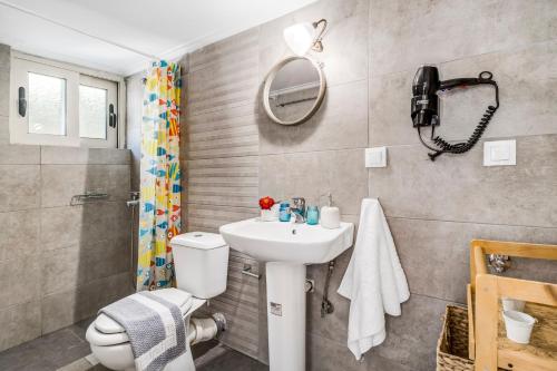 a bathroom with a sink and a toilet and a shower at Oceanida Aelia Room 2 in Nikiana
